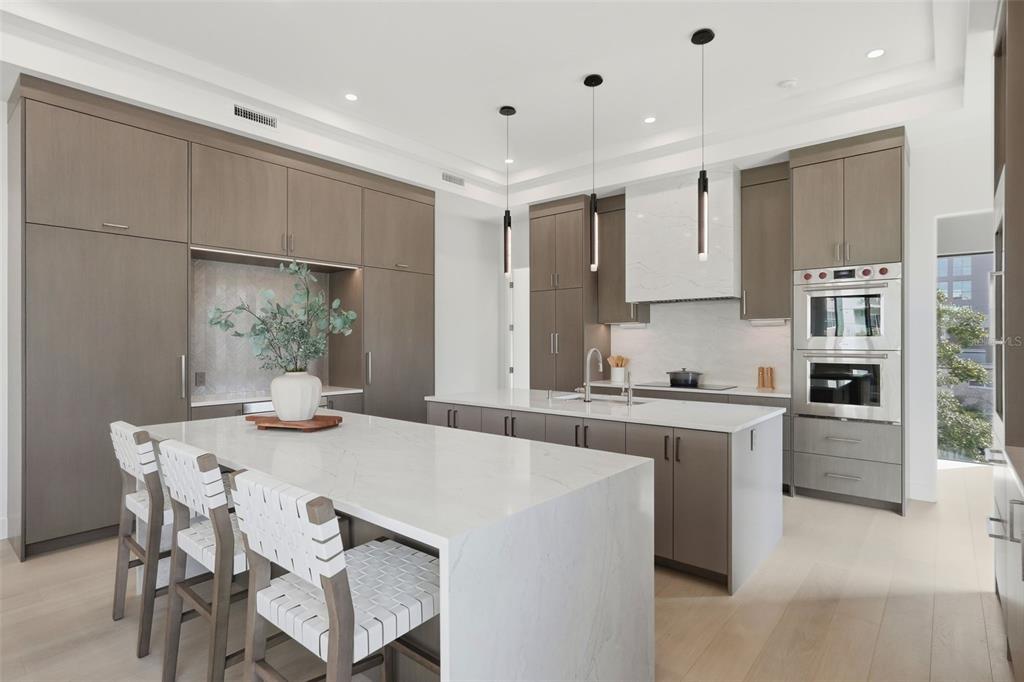 A modern kitchen features light wood cabinetry, white marble countertops, and a large central island — 321 2ND STREET N, ST PETERSBURG, FL