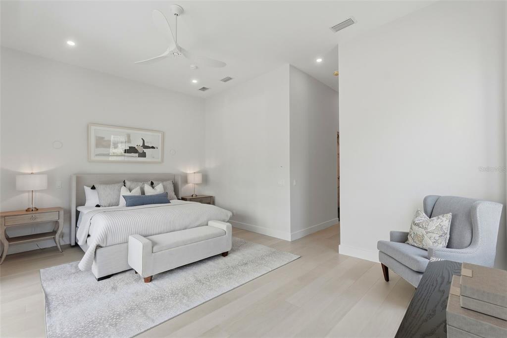 A modern bedroom features a bed, an armchair, and light wood flooring — 321 2ND STREET N, ST PETERSBURG, FL