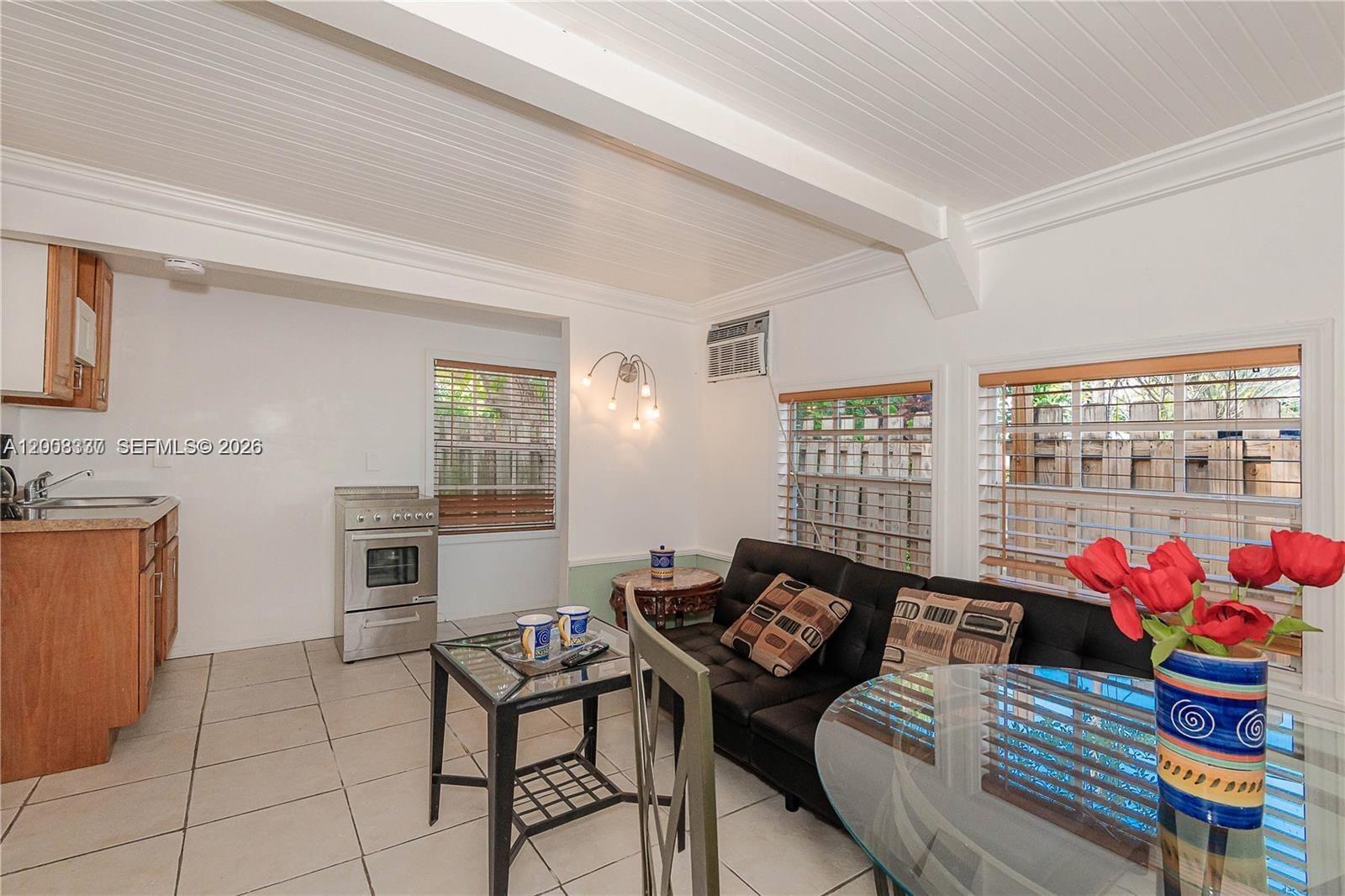 A small living area features a kitchenette, tile flooring, and a black sofa — 1611 Fletcher St # 2, Hollywood FL 33020, HOLLYWOOD, FL