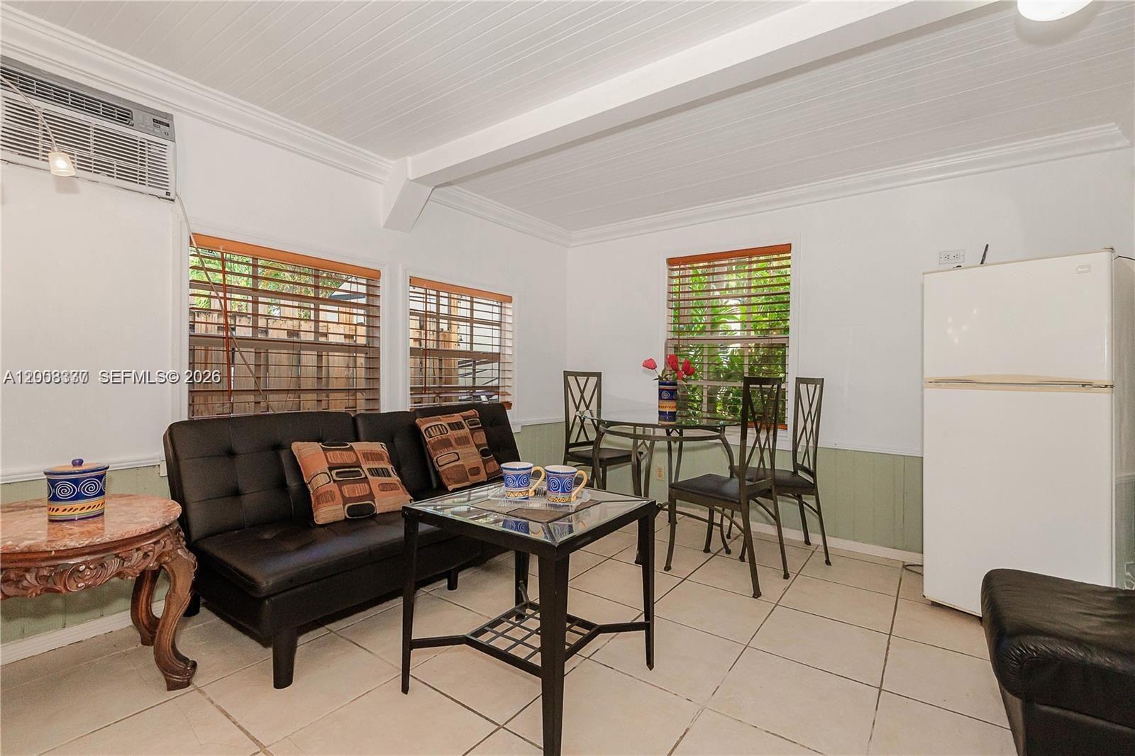 A small living and dining area features a black sofa, glass table, and tile flooring — 1611 Fletcher St # 2, Hollywood FL 33020, HOLLYWOOD, FL