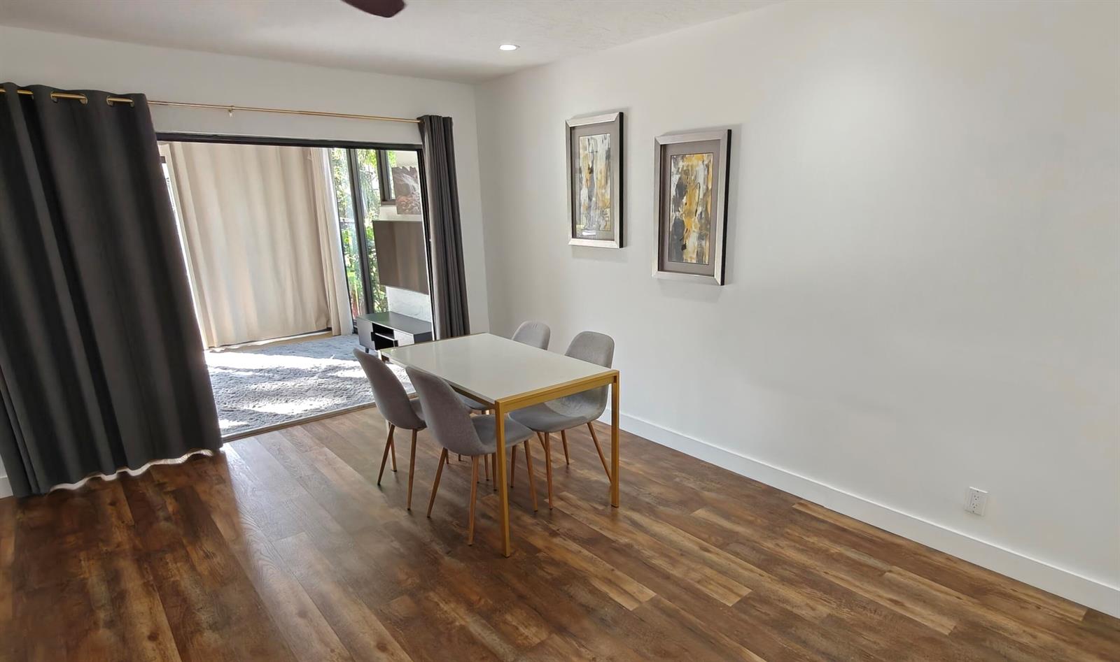 A dining area features a white table with four grey chairs on wood-look flooring — 385 NW 36th Avenue, Deerfield Beach FL 33442, DEERFIELD BEACH, FL