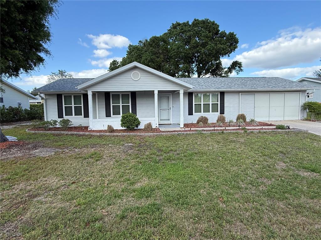 A single-story house with light gray siding, a covered porch, and an attached garage — 8287 SW 116TH ST STREET, OCALA, FL