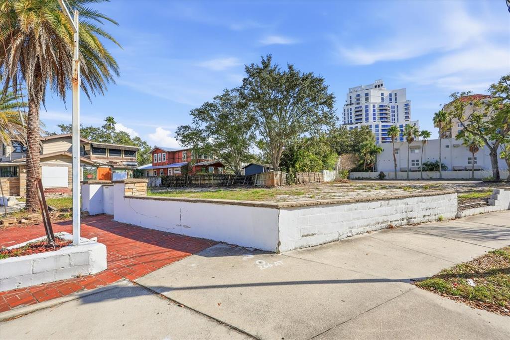 A vacant, fenced-in lot with a low concrete wall and a brick walkway — 1504 S HOWARD AVENUE, TAMPA, FL