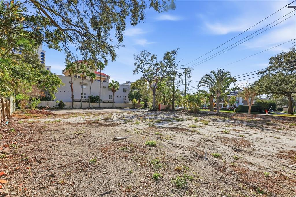 A vacant, sandy lot with scattered vegetation and trees under a clear blue sky — 1504 S HOWARD AVENUE, TAMPA, FL