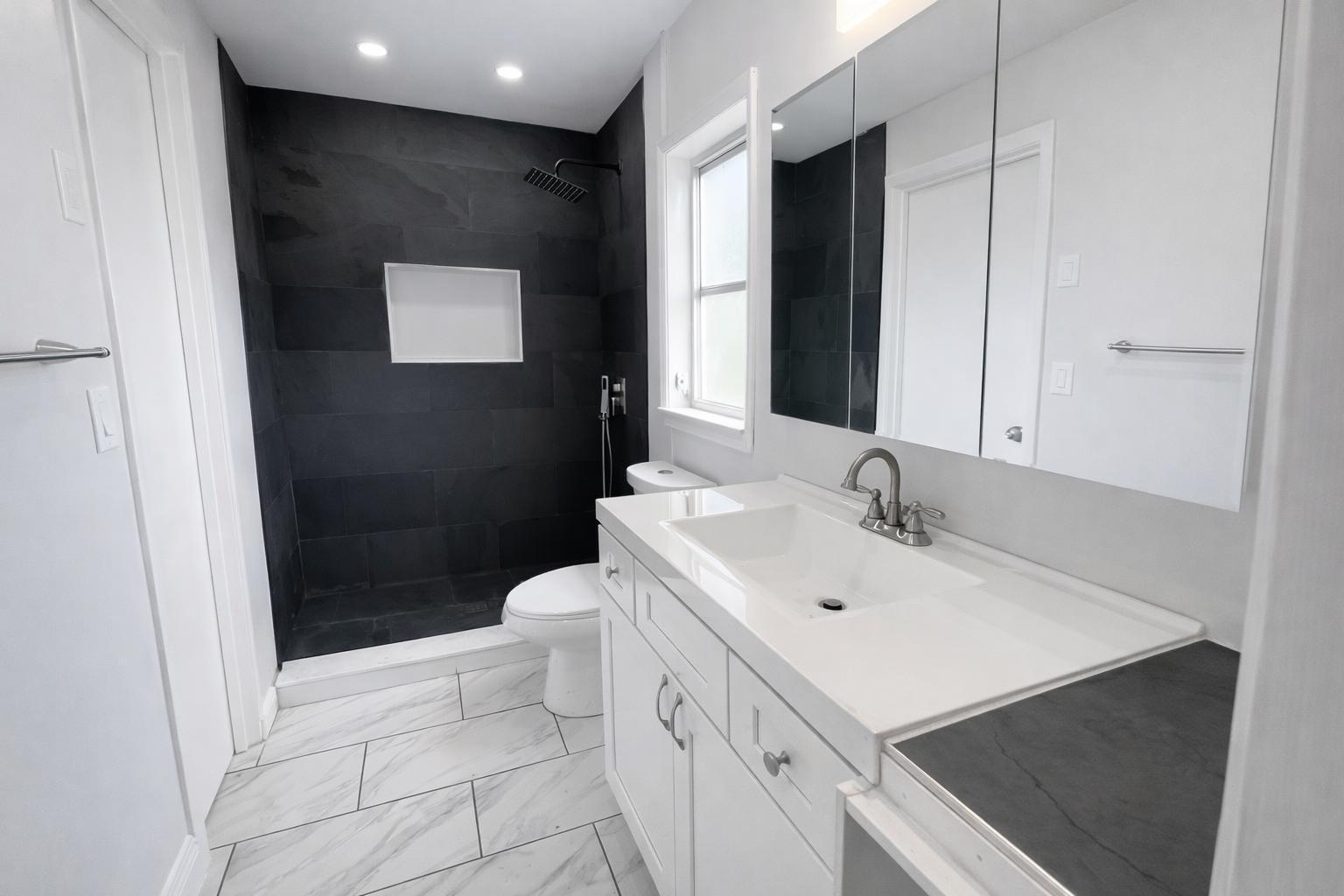 A modern bathroom features a black tiled shower, white vanity, and light marble-patterned floor tiles — 1504 41st Avenue, Vero Beach FL 32960, VERO BEACH, FL