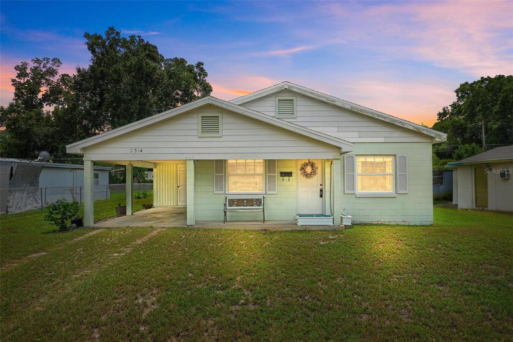 A single-story house with a light green exterior, a front porch, and an attached carport — 2514 DRAKE DRIVE, ORLANDO, FL