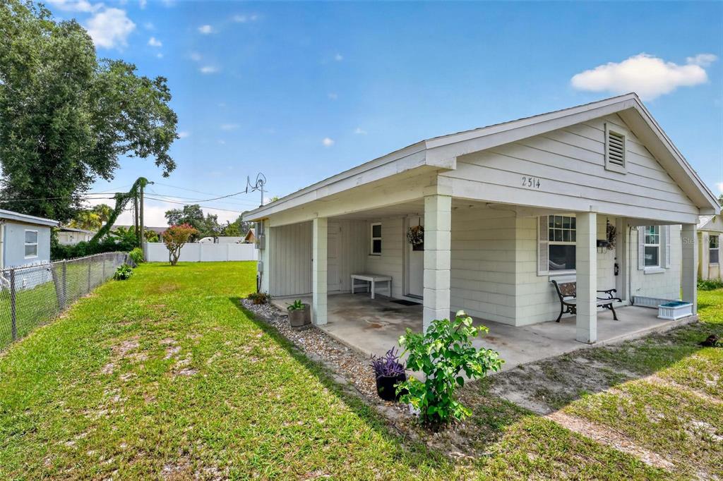 The exterior of a light-colored house features a covered front porch and a grassy yard — 2514 DRAKE DRIVE, ORLANDO, FL