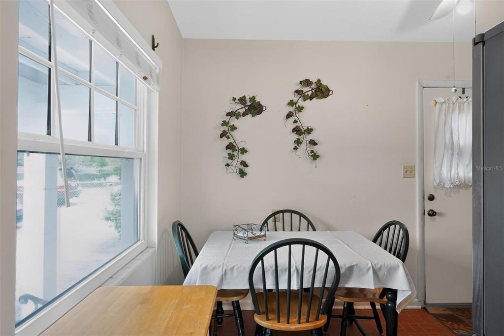 A dining area features a table with chairs, a window, and wall-mounted vine decorations — 2514 DRAKE DRIVE, ORLANDO, FL