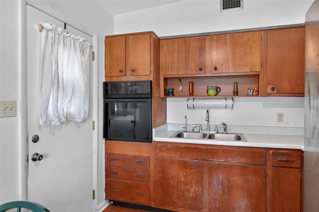 A kitchen features wood cabinets, a double-basin sink, and a built-in wall oven — 2514 DRAKE DRIVE, ORLANDO, FL