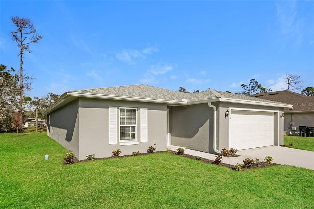 A single-story gray house with a white garage door and white shutters on a lawn — 4458 WINDSONG AVENUE, NORTH PORT, FL