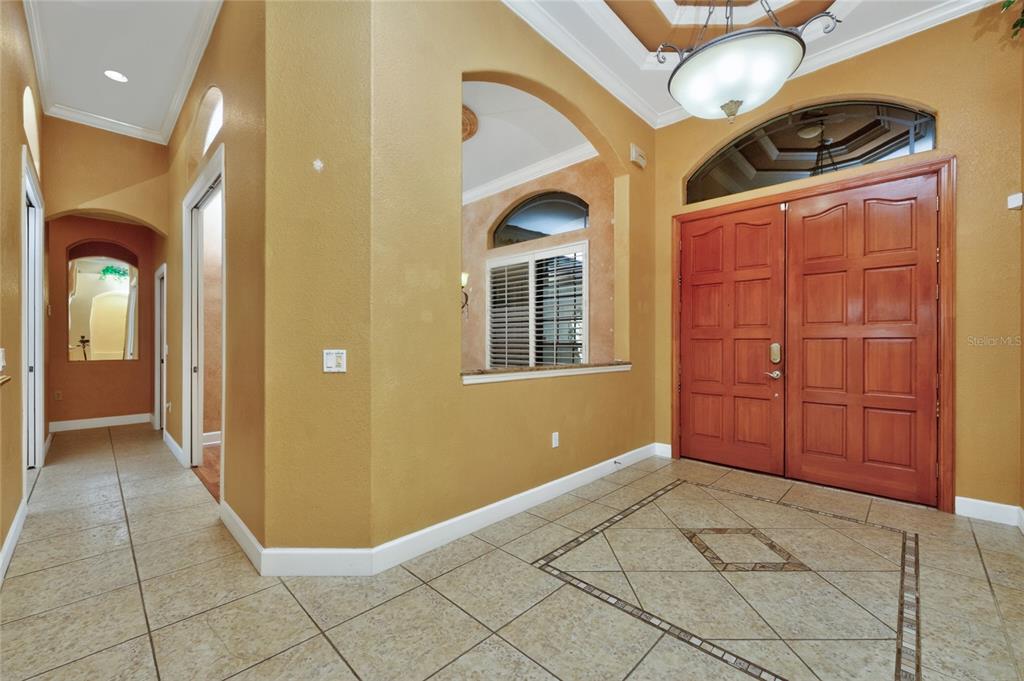 An entryway with tile flooring, a double wooden door, and a decorative ceiling light fixture — 1141 ROTONDA CIRCLE, ROTONDA WEST, FL