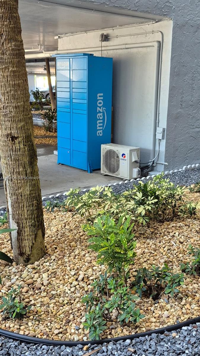 An Amazon locker and a Gree air conditioning unit sit outside against a gray wall — 8020 Hampton Blvd # 202, North Lauderdale FL 33068, NORTH LAUDERDALE, FL