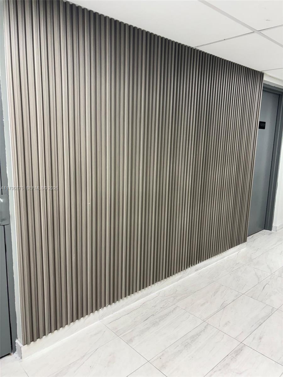 A wall with vertical wood-look slats stands next to a doorway on a tiled floor — 701 Three Islands Blvd # 409, Hallandale Beach FL 33009, HALLANDALE BEACH, FL