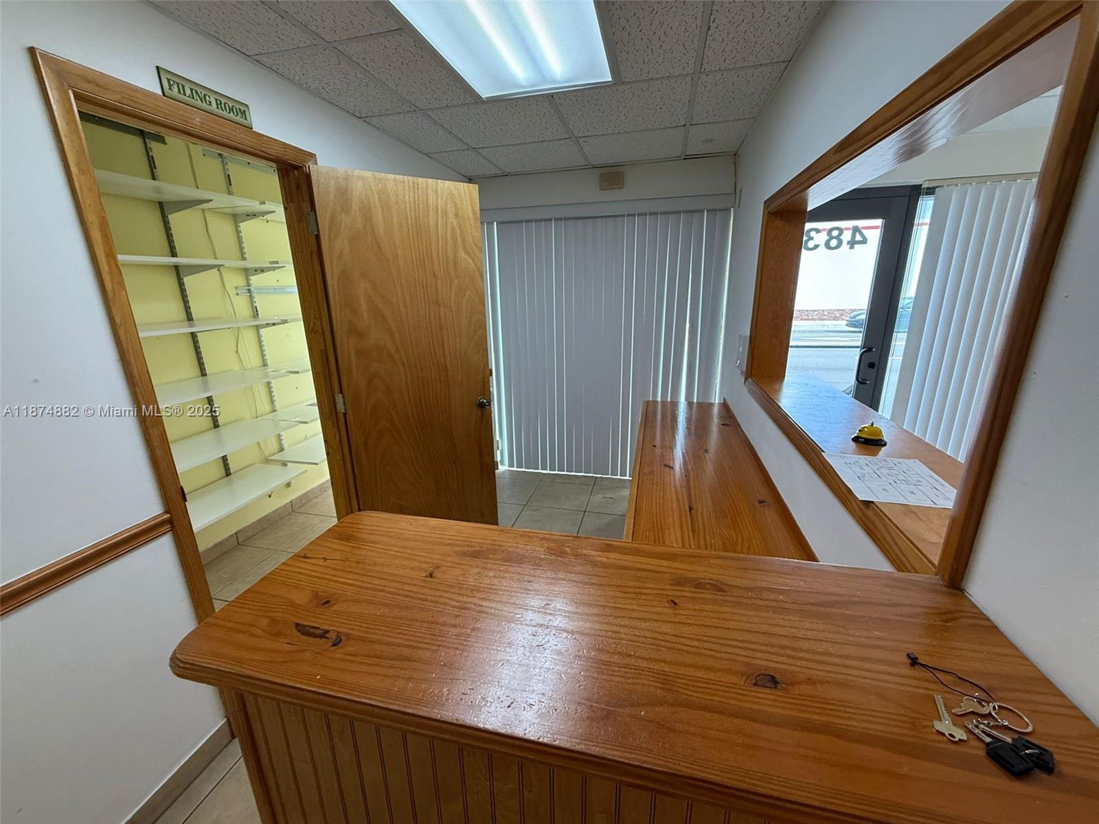A reception area features a wooden counter, a filing room with shelves, and vertical blinds — 801 Monterey St # 101, Coral Gables FL 33134, CORAL GABLES, FL