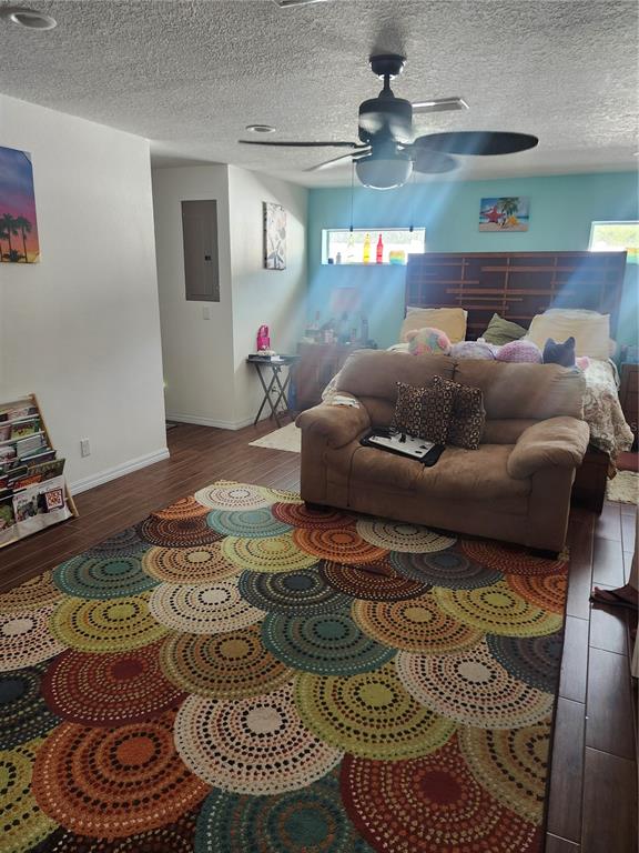 A bedroom features a brown loveseat, a large circular-patterned area rug, and a ceiling fan — 2242 WOOD COURT, DELTONA, FL