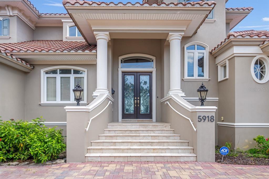 The exterior of a house features a stone staircase leading to a double front door — 5918 BAHAMA SHORES DRIVE S, ST PETERSBURG, FL