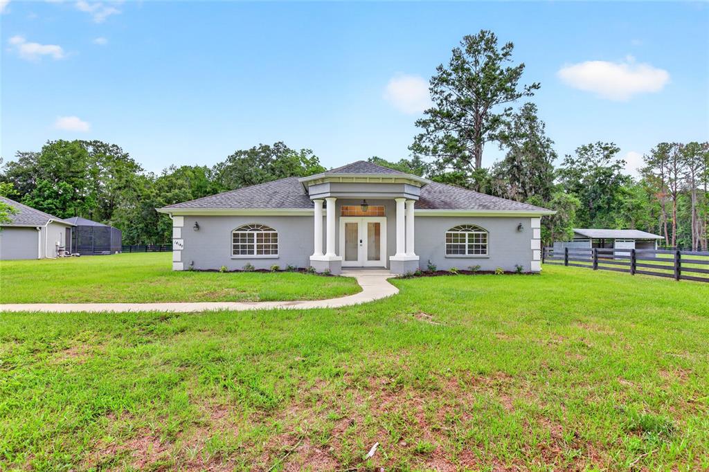 A single-story house with a gray exterior, white columns, and a front walkway — 14144 NW 141ST AVENUE, WILLISTON, FL