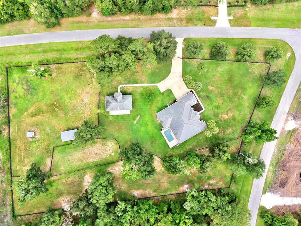An aerial view shows a house with a pool, a detached structure, and fenced grounds — 14144 NW 141ST AVENUE, WILLISTON, FL