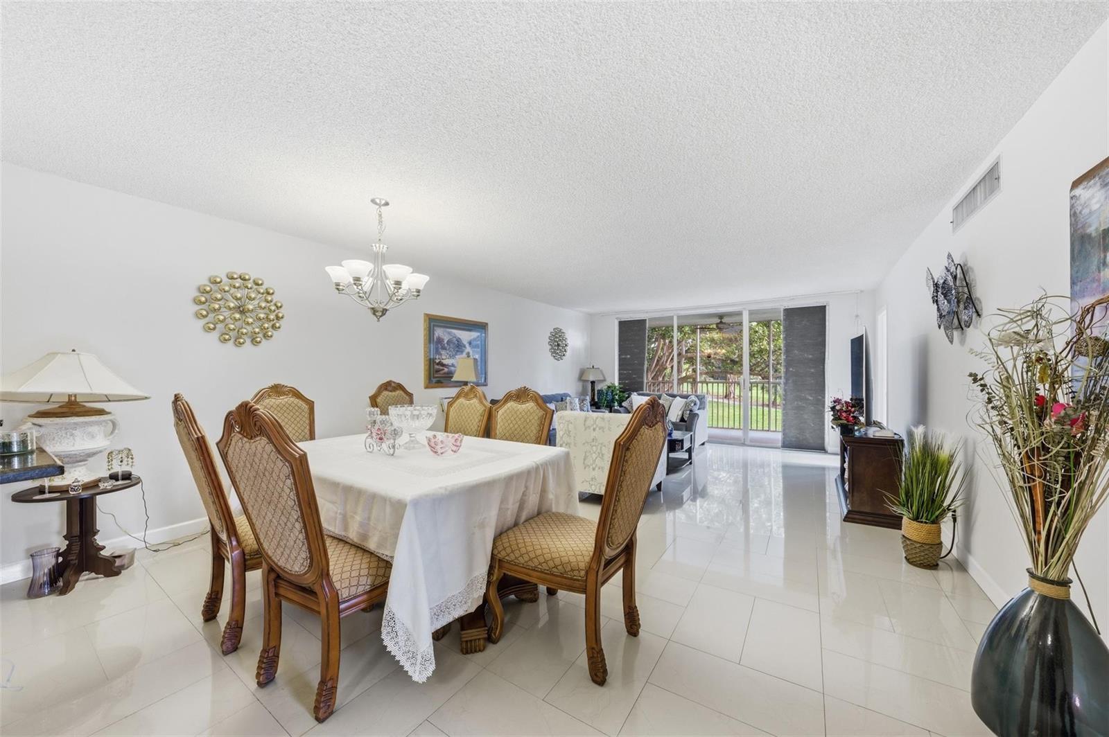 A dining area with a table and chairs sits in an open-concept room with tile floors — 3000 S Course Drive # 201, Pompano Beach FL 33069, POMPANO BEACH, FL