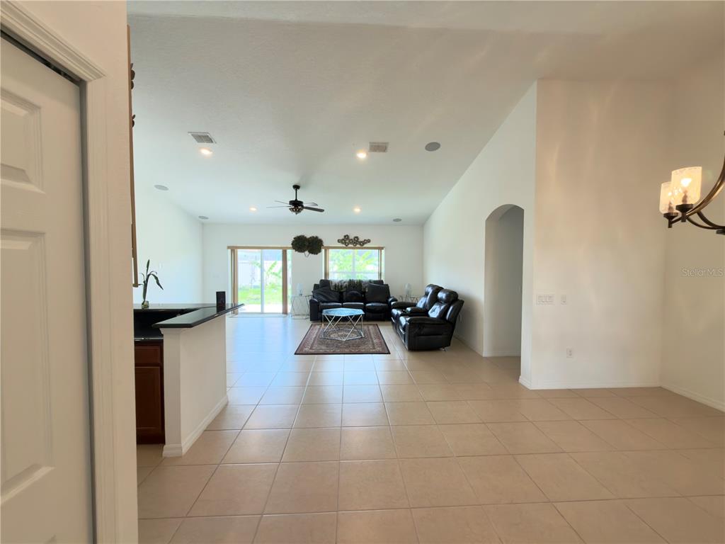 A living room with tile floors, a ceiling fan, and a sliding glass door — 3311 BENT PADDLE DRIVE, KISSIMMEE, FL