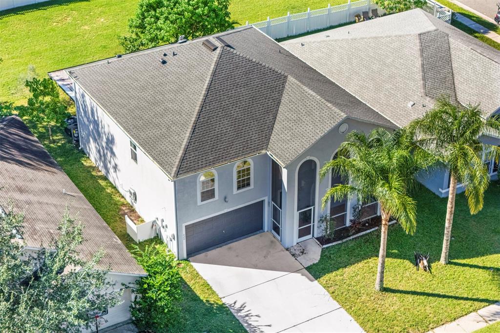An aerial view of a gray suburban house with a shingled roof and palm tree — 420 BLAKE AVENUE, DAVENPORT, FL