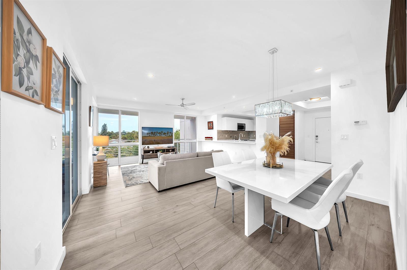 A bright open-concept living and dining area features white walls, light wood floors, and balcony views — 51 SE 19th Avenue # 303, Deerfield Beach FL 33441, DEERFIELD BEACH, FL