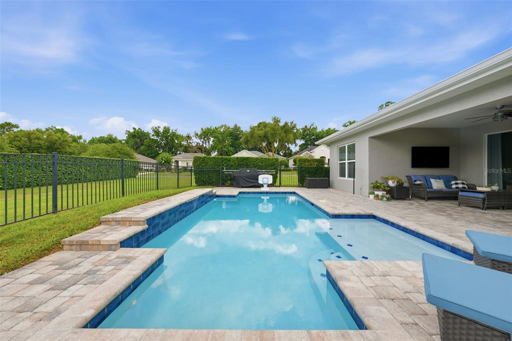 A living room with a sectional sofa, wooden coffee table, and sliding doors to a pool — 3983 SE 5TH AVENUE, OCALA, FL