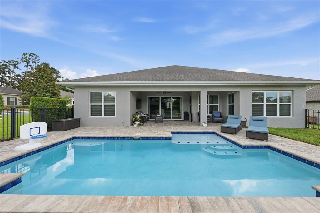 A modern kitchen features white cabinetry, a central island with bar seating, and wood-look flooring — 3983 SE 5TH AVENUE, OCALA, FL
