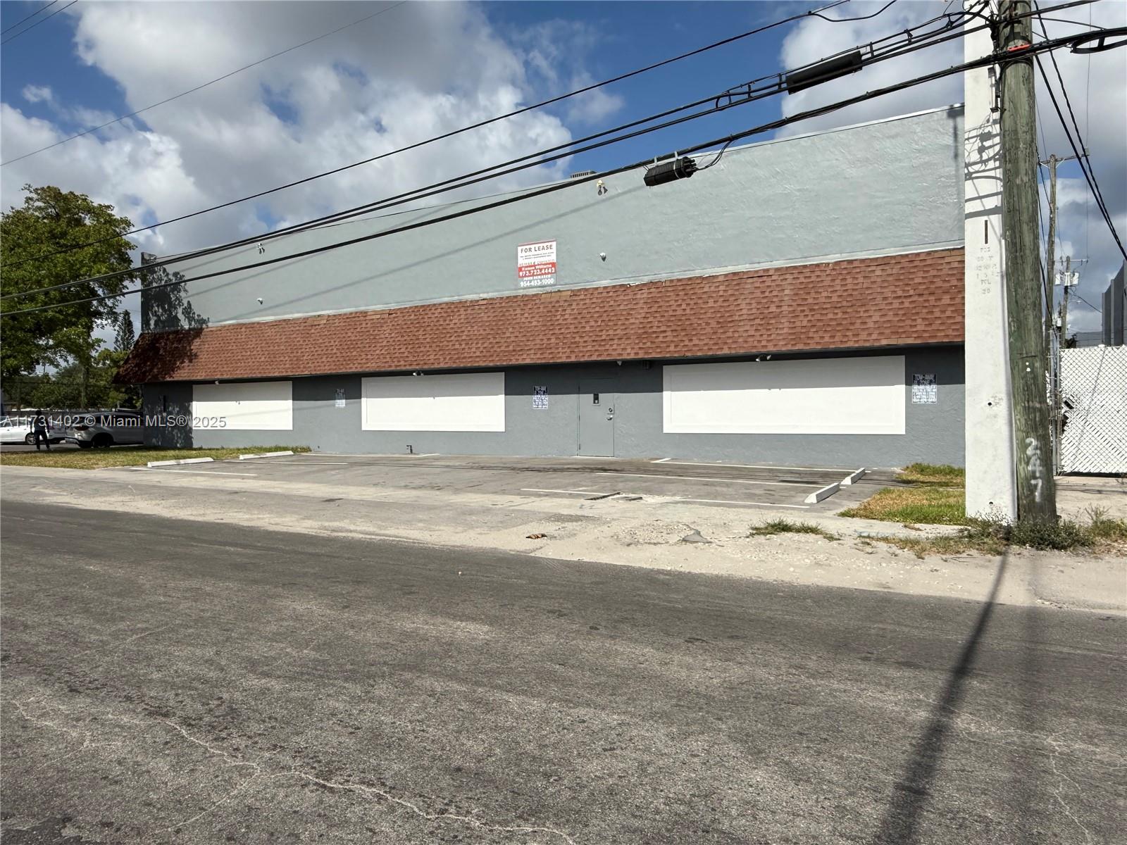A gray commercial building with a brown shingled awning and a paved parking lot — 5801 Plunkett St, Hollywood FL 33023, HOLLYWOOD, FL