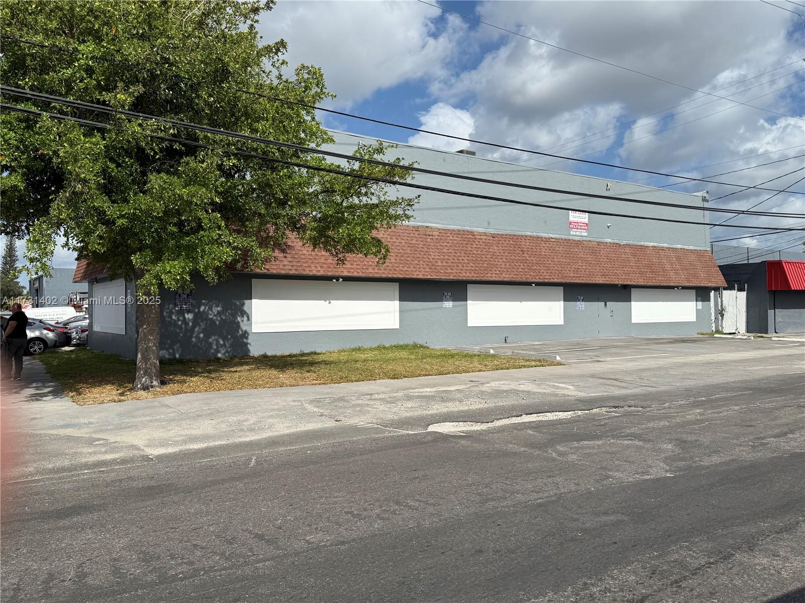 A gray commercial building with a brown shingled awning and boarded-up windows — 5801 Plunkett St, Hollywood FL 33023, HOLLYWOOD, FL