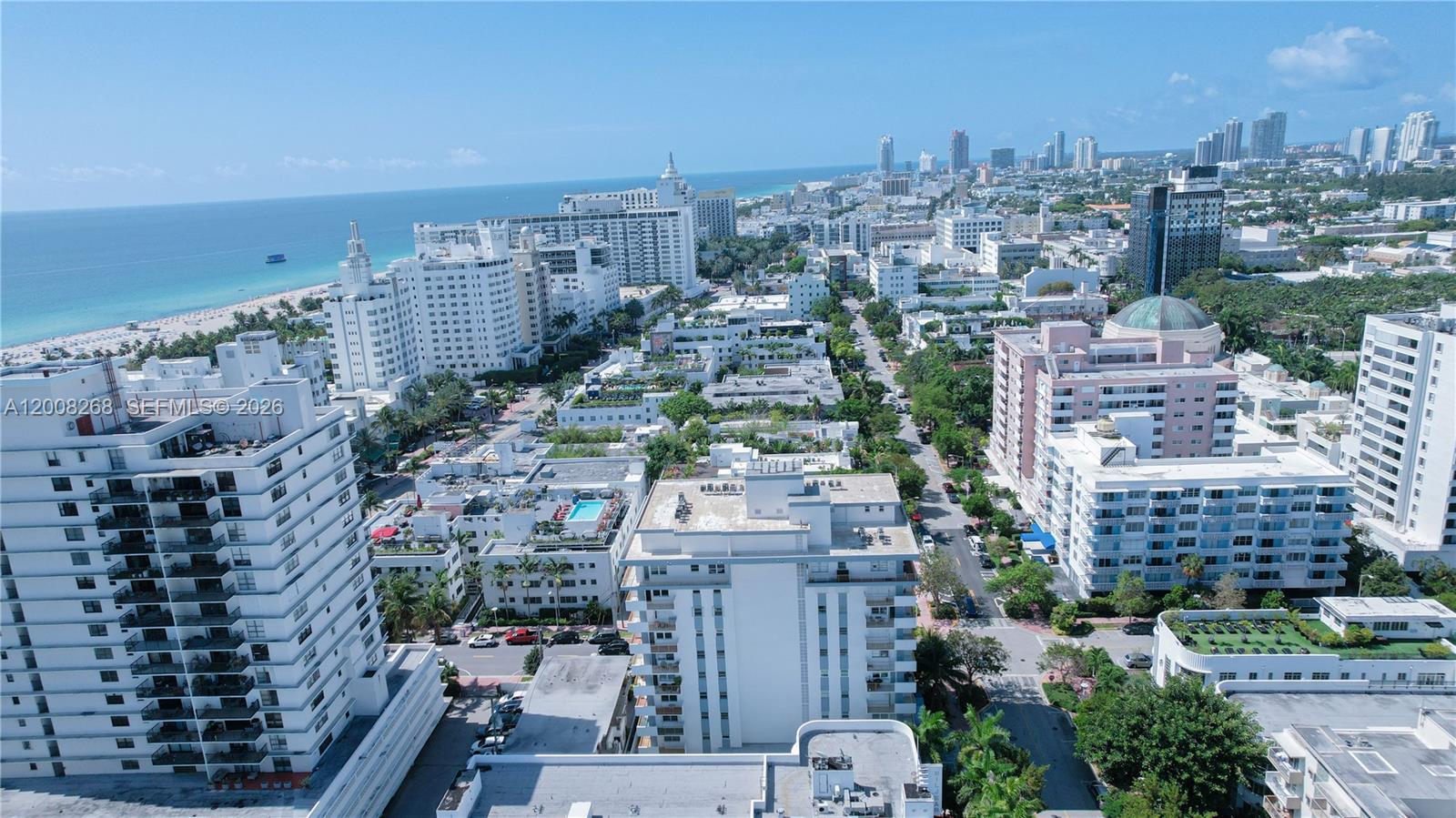 An aerial view shows a dense urban neighborhood with high-rise buildings near a sandy beach — 245 18th St # 605, Miami Beach FL 33139, MIAMI BEACH, FL