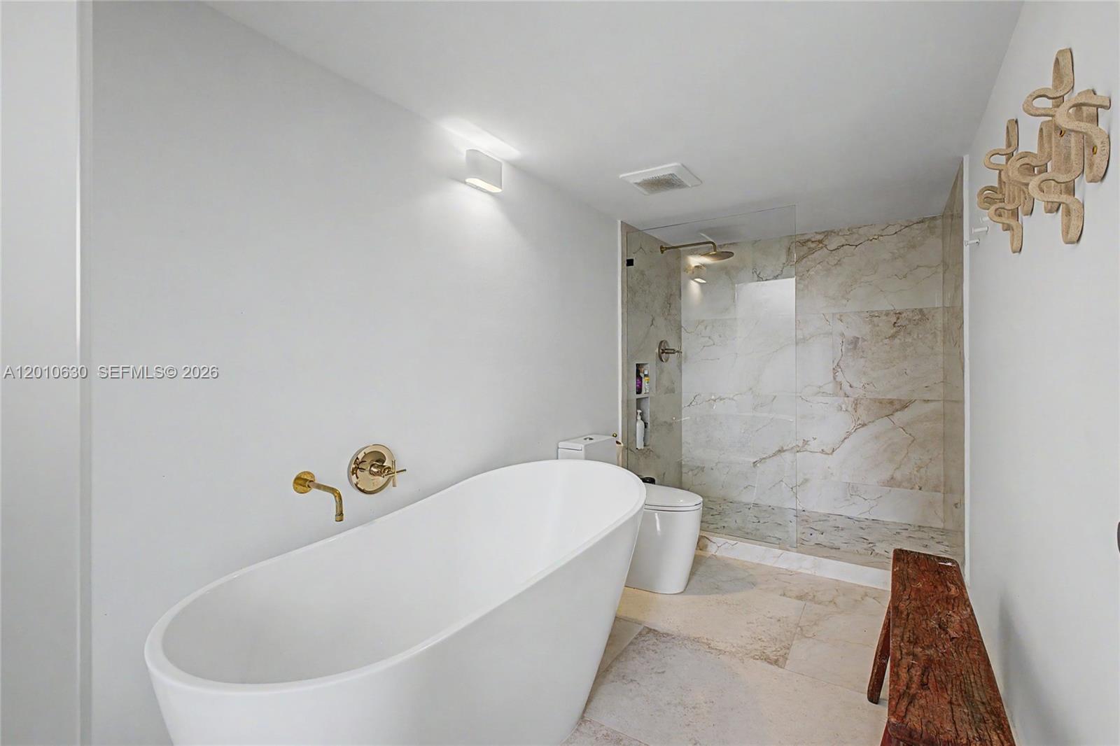 A modern bathroom features a freestanding white tub, a glass-enclosed shower, and marble tile flooring — 2575 S Bayshore Dr # 4A, Miami FL 33133, MIAMI, FL