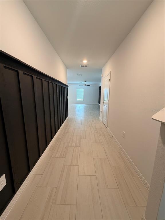 A hallway features light tile flooring and a dark wood board and batten accent wall — 12490 SWEET ANGEL AURA WAY, PARRISH, FL