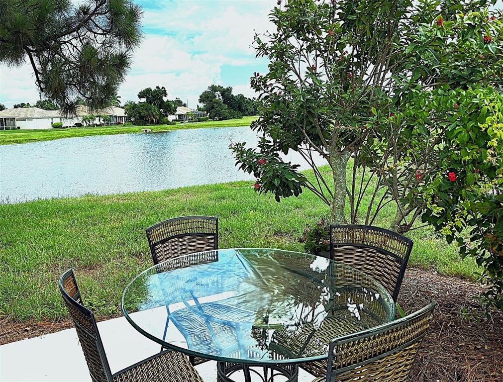 An aerial view shows a single-story house with a tile roof, driveway, and backyard pond — 6724 GREENVIEW LANE, ENGLEWOOD, FL