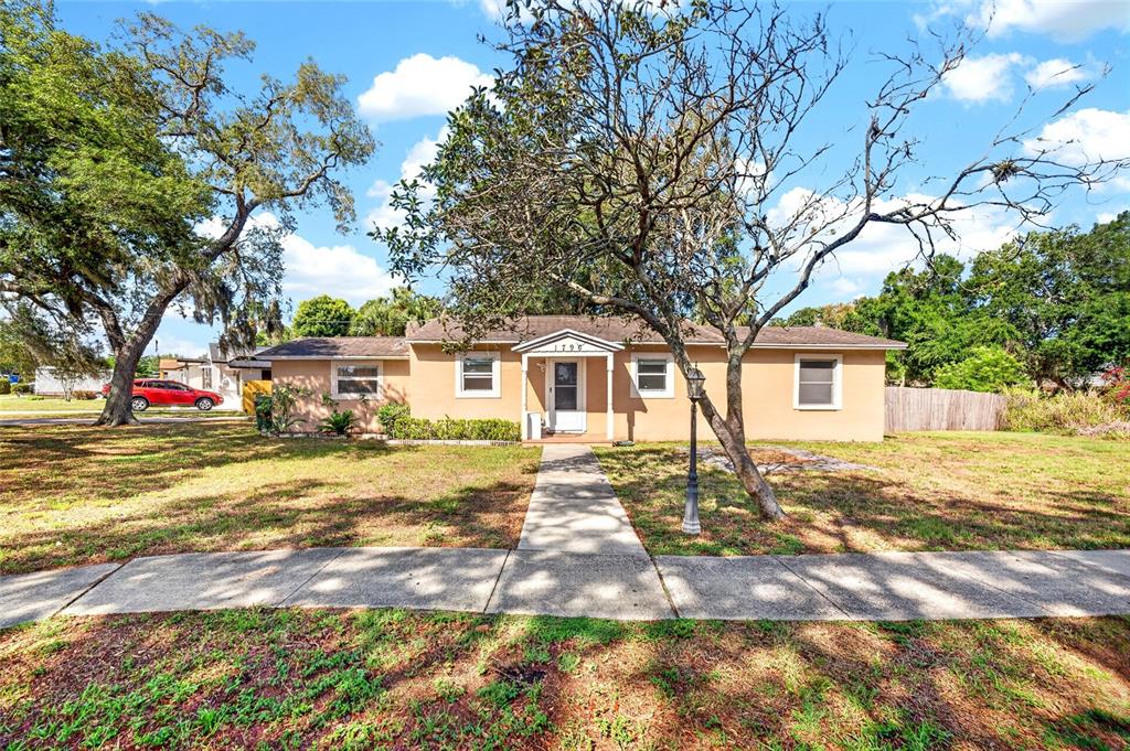 A single-story tan house with a central front door and a concrete walkway — 1796 HARBOR DRIVE, CLEARWATER, FL