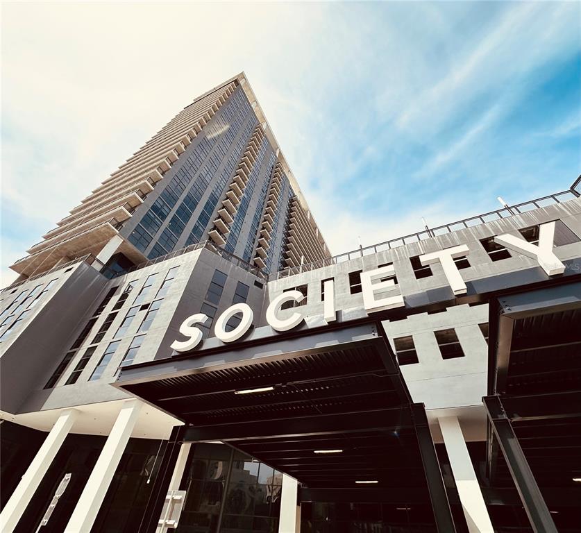 A low-angle exterior view of a modern high-rise building with the word SOCIETY displayed prominently — 434 N ORANGE AVENUE, ORLANDO, FL