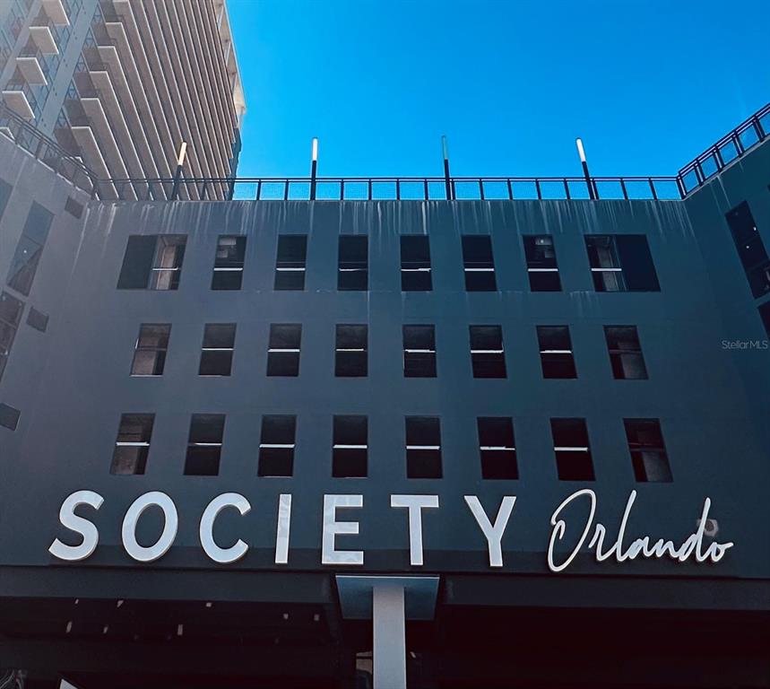 The exterior of a modern building features the sign SOCIETY Orlando below several rows of windows — 434 N ORANGE AVENUE, ORLANDO, FL