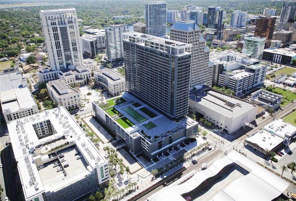 Aerial view of a modern high-rise apartment building with a rooftop pool and parking garage — 434 N ORANGE AVENUE, ORLANDO, FL