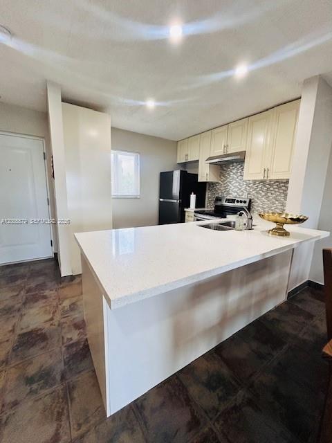A kitchen features a white quartz island, cream-colored cabinets, and dark tile flooring — 7740 Camino Real # G404, Miami FL 33143, MIAMI, FL