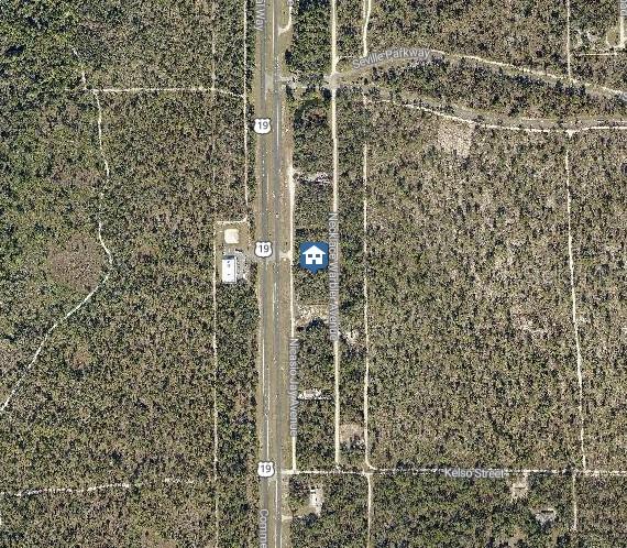 This is an aerial map view showing a residential lot located along a highway — LOT 16 NECKLACE WARBLER AVENUE, WEEKI WACHEE, FL