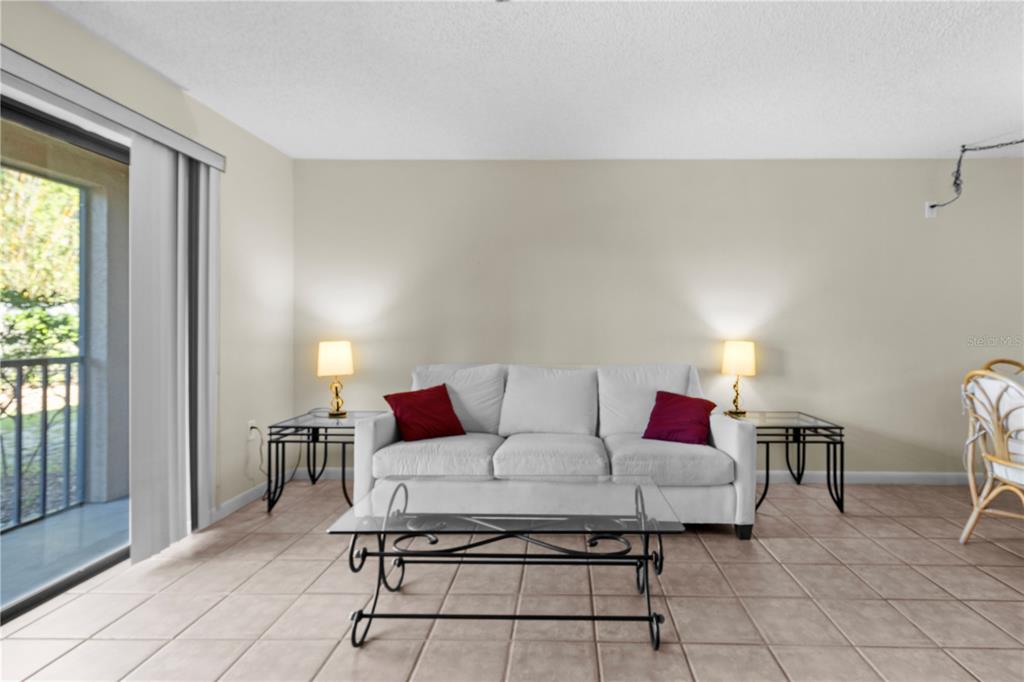 A living room features a white sofa, glass coffee table, side tables, and tile flooring — 2851 SW 32ND AVENUE UNIT B6, OCALA, FL