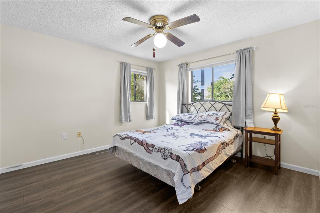 A bedroom features a bed with horse-patterned bedding, a ceiling fan, and wood-look flooring — 2851 SW 32ND AVENUE UNIT B6, OCALA, FL