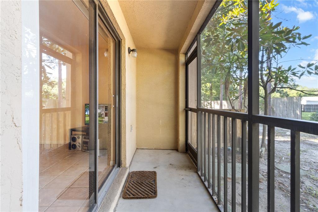 A screened-in patio with a concrete floor and sliding glass doors leading indoors — 2851 SW 32ND AVENUE UNIT B6, OCALA, FL