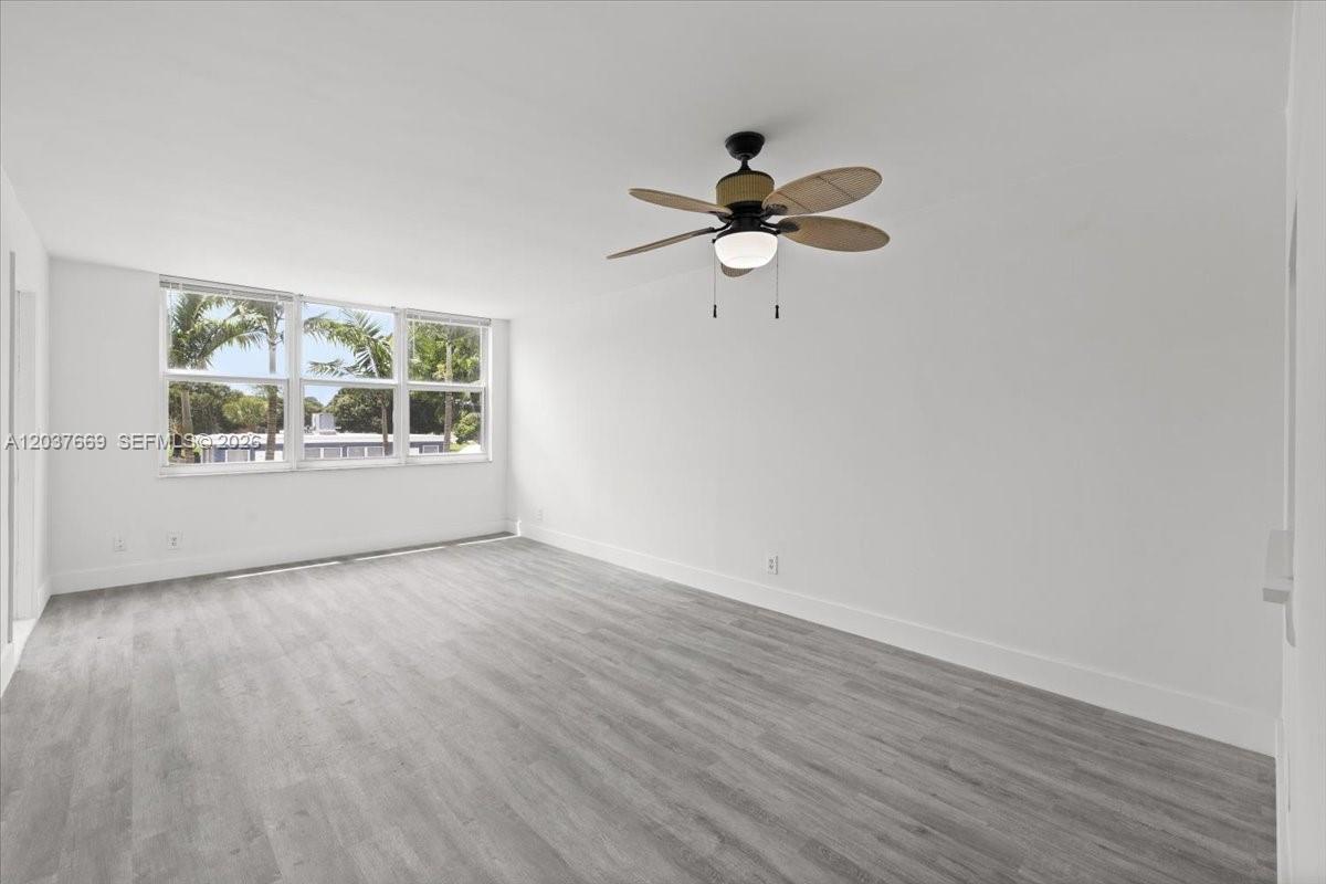 An empty room features white walls, light gray wood-look flooring, and a ceiling fan — 9441 Evergreen Pl # 206, Davie FL 33324, DAVIE, FL