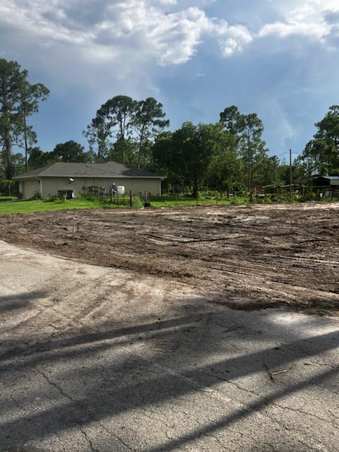 A cleared dirt lot sits in front of a house with a gray roof — 2309 Johns Avenue, FL 33920, FL