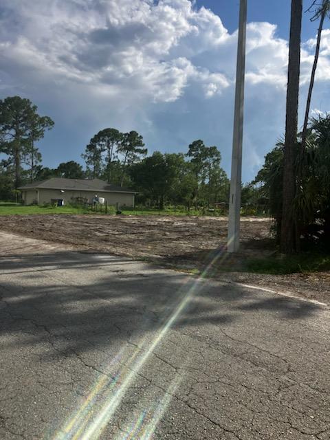 A vacant, cleared dirt lot sits next to a paved road and a utility pole — 2309 Johns Avenue, FL 33920, FL