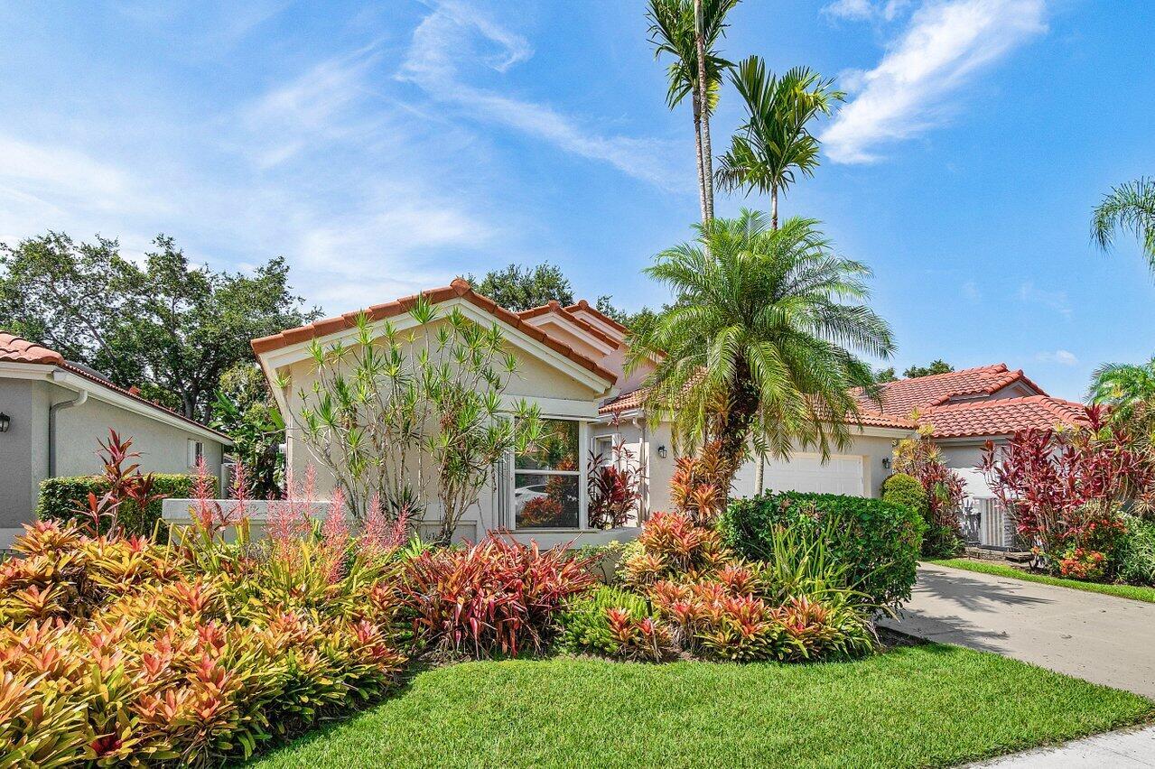 A single-story house with a tile roof, palm trees, and colorful landscaping in the front — 9763 Harbour Lake Circle S, Boynton Beach FL 33437, BOYNTON BEACH, FL