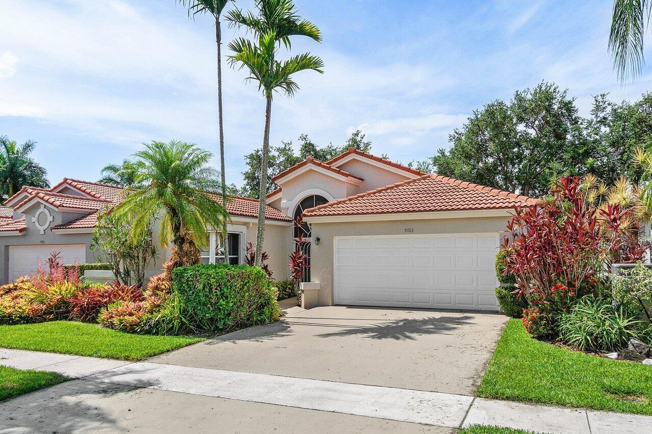 A single-story house with a white garage, terracotta roof, and lush tropical landscaping — 9763 Harbour Lake Circle S, Boynton Beach FL 33437, BOYNTON BEACH, FL