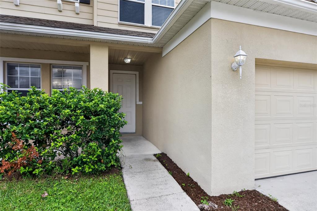 A concrete walkway leads to the front door of a house with a garage — 1215 ALAPAHA LANE, ORLANDO, FL