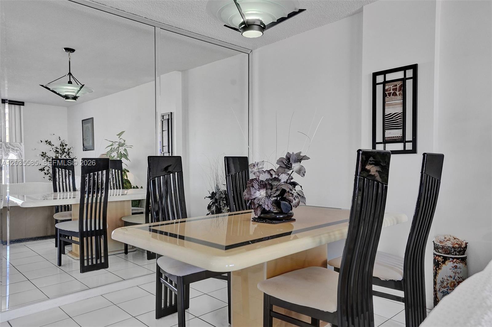 A dining room features a glass-topped table, black slatted chairs, and a large mirrored wall — 3113 S Ocean Dr # 803, Hallandale Beach FL 33009, HALLANDALE BEACH, FL